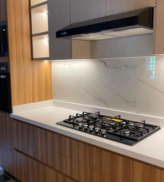 Cubierta en granito blanco, campana negra — Nogal, Cocinas & Closets Stylo