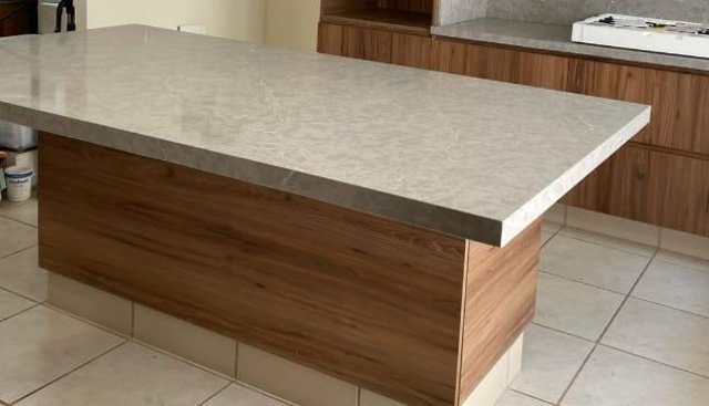 Isla central en granito con base nogal — Nogal, Cocinas & Closets Stylo