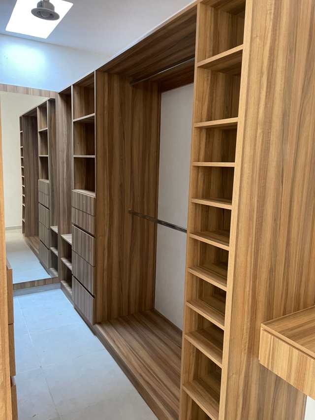 Walk-in closet en nogal, pasillo completo — Closets y Vestidores, Cocinas & Closets Stylo